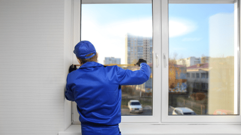 Man in Blue suit measuring windows